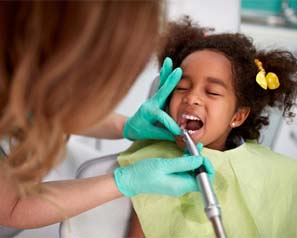 Little girl visiting her emergency pediatric dentist for checkup