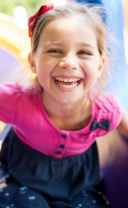 Young girl laughing on outdoor playground