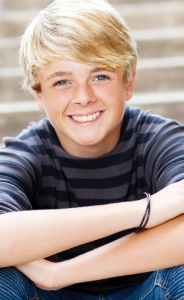 Smiling teen boy sitting at bottom of staircase