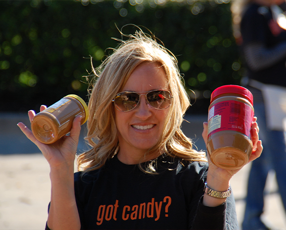 Doctor Rozas holding peanut butter for a food drive