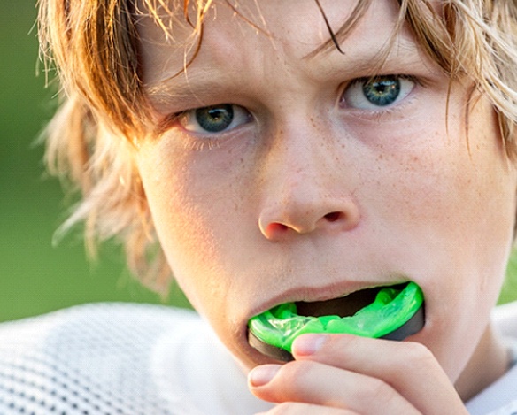A young boy preparing to insert a sportsguard for teens in Coppell before a football game