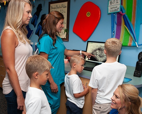 Kids and dental team member looking at digital x-rays