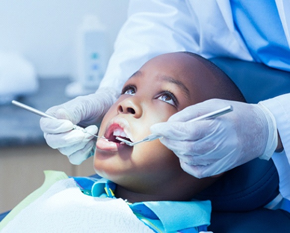 A young boy having his teeth examined after pulp therapy