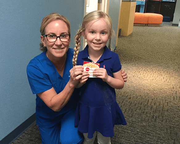 Dentist giving young girl an award
