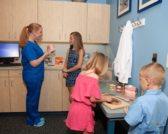 Three kids and dental team member in treatment room