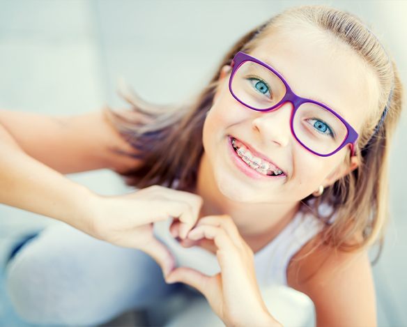 Teen girl with braces smiling after orthodontic evaluation