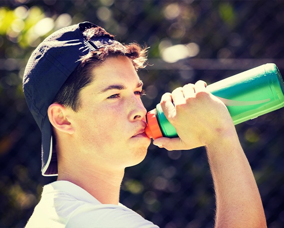 Teen boy drinking a sports drink
