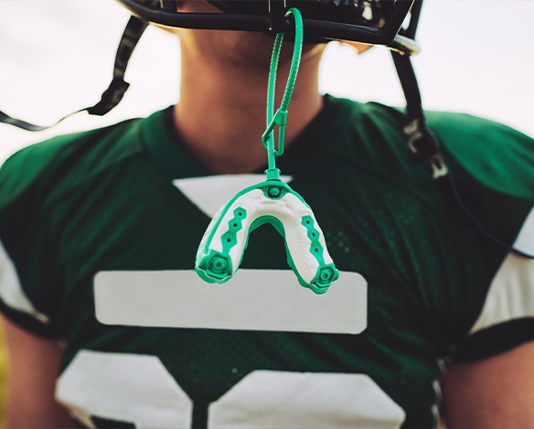 Green mouthguard hanging from football helmet