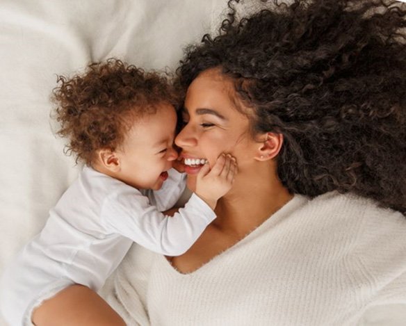 Happy mother playing with her baby 