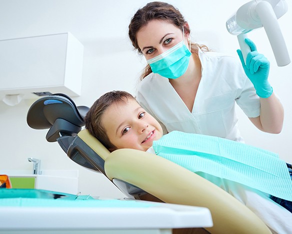A female pediatric dentist takes care of a young dental patient’s smile