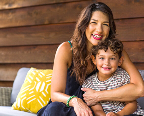 A mother and her son sitting outside on a couch and smiling after identifying ways to help prevent cavities with xylitol in Coppell Texas 