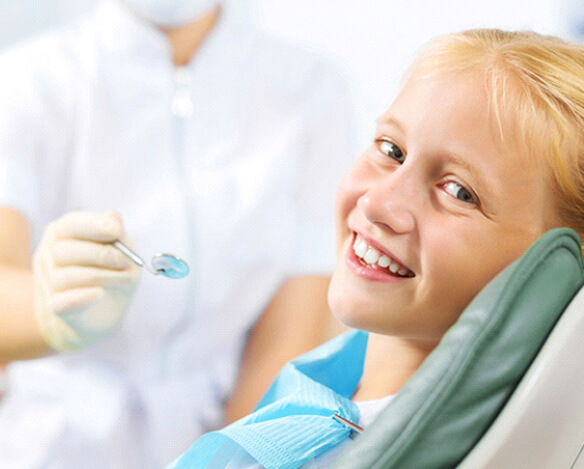 A young girl smiling while waiting to see a kid’s dentist in Coppell