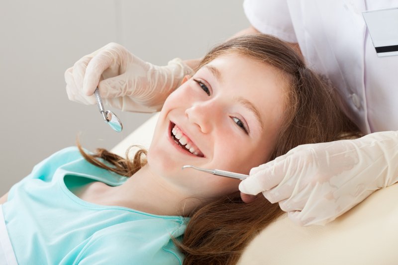 a little girl smiling at her dentist during a regular checkup