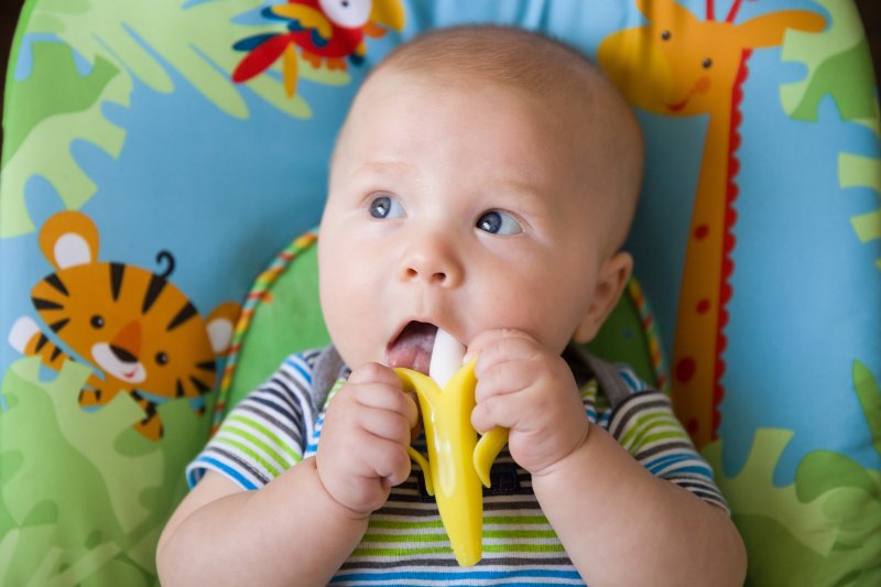 a baby chewing on a teething toy