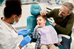 father and child talking to dentist 