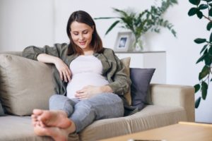 Pregnant woman relaxing while looking at her belly