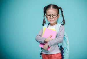 young girl with backpack smiling