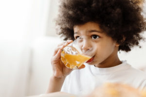 a child drinking a glass of juice